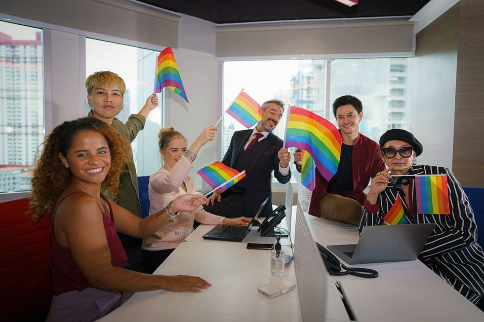 un groupe de personnes tenant des drapeaux arc-en-ciel