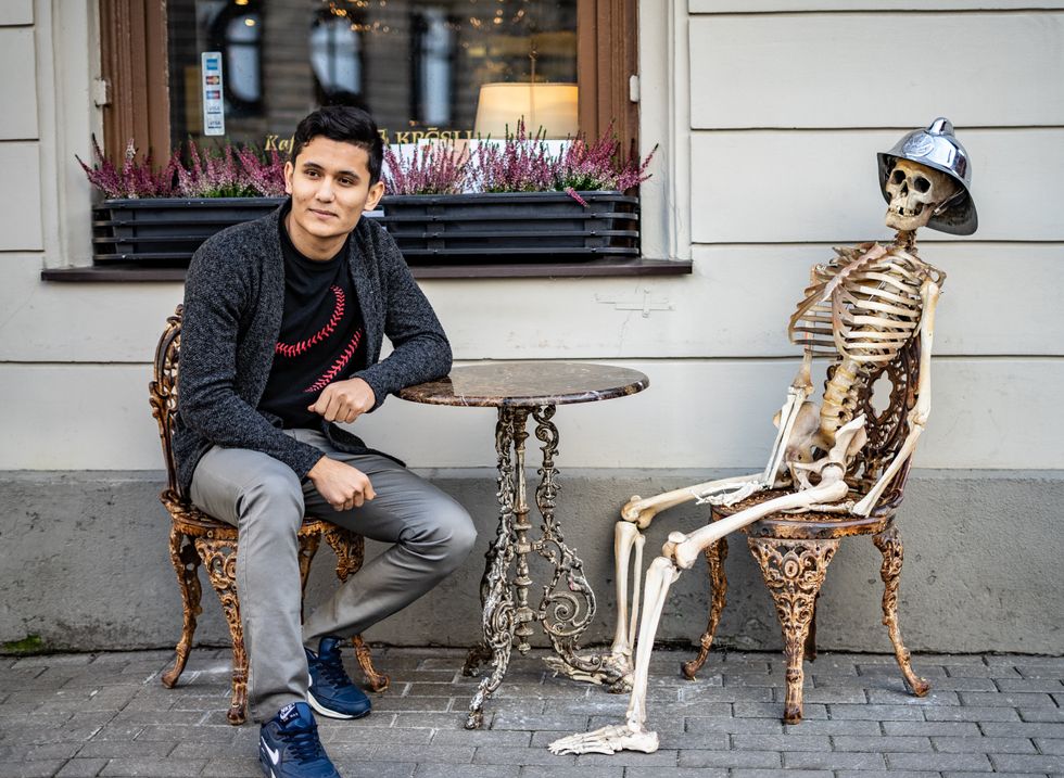 homme assis avec un squelette dehors