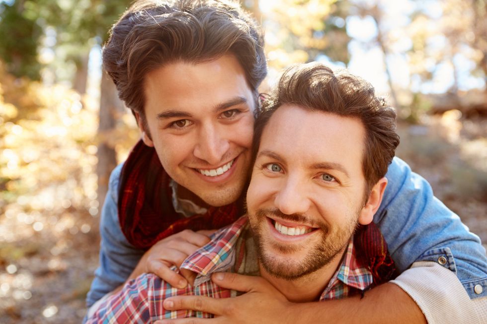 deux hommes souriants dans les bois