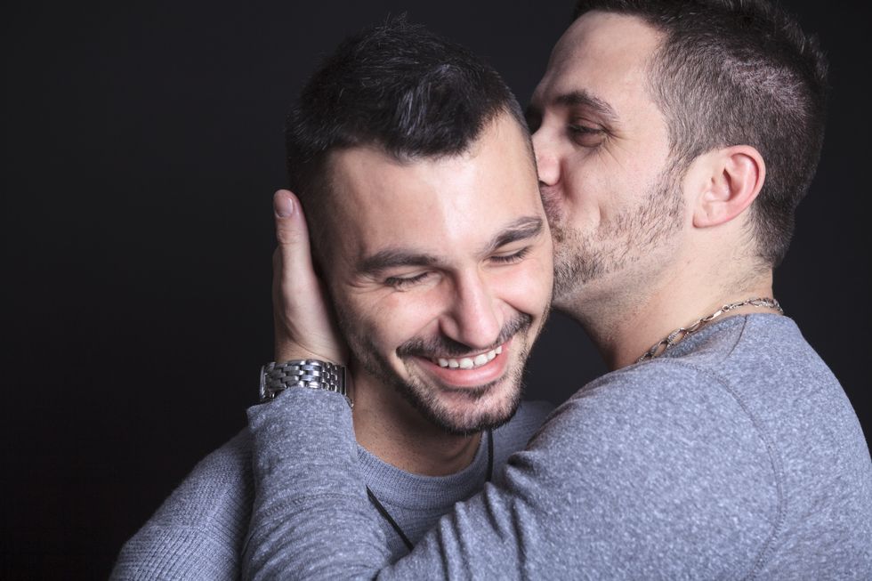 Homme embrassant la joue d'un autre homme
