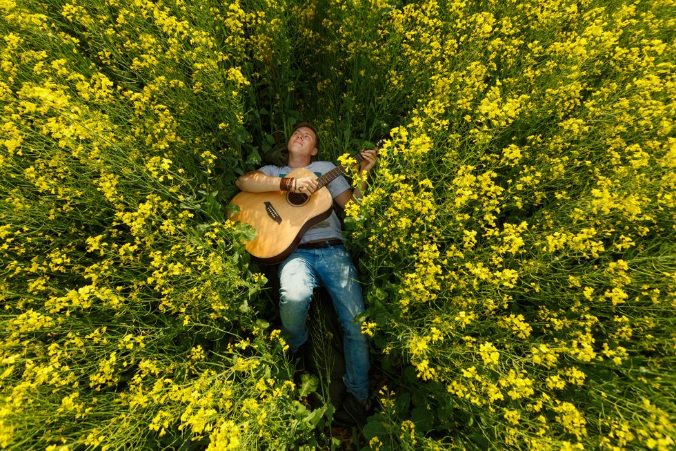 homme jouant de la guitare dans le champ