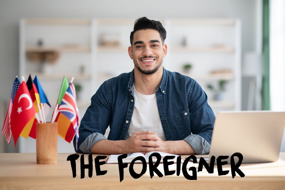 Homme souriant à côté des drapeaux des pays