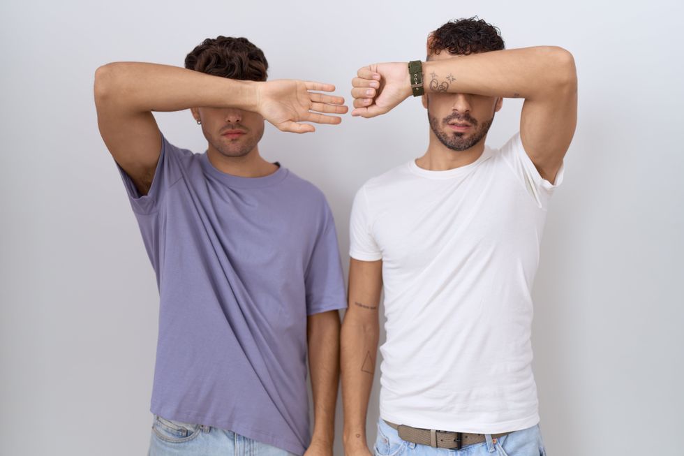 deux hommes se couvrant les yeux