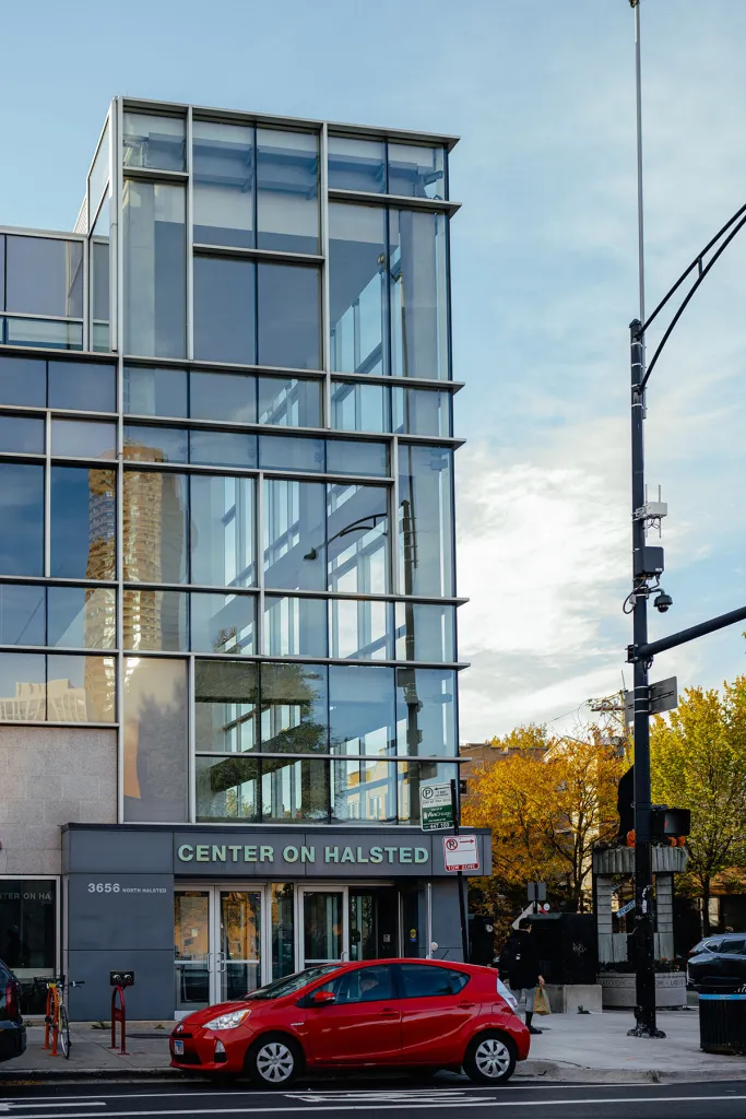 Bâtiment à la façade de verre avec une pancarte indiquant « Center on Halsted » au niveau de la rue.